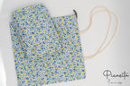 Conjunto de neceser y bolsa con diseño de flores pequeñas en color azul y amarillo.