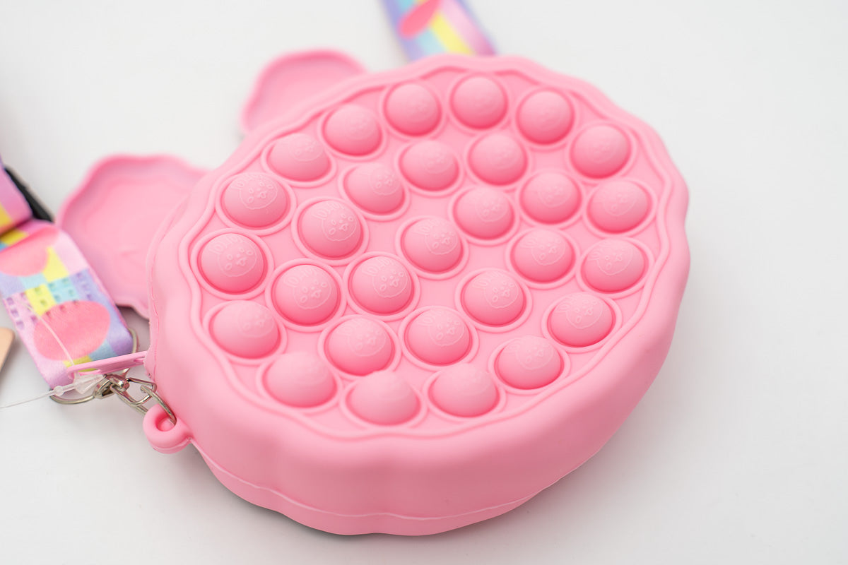 Reverso de bolso de conejo rosa mostrando el relieve de burbujas pop-it.