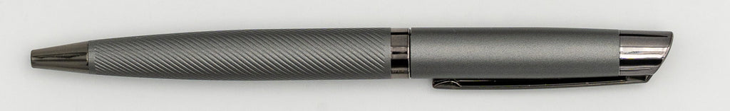 Caneta de metal cinzenta com parte superior lisa e corpo de linhas diagonais.