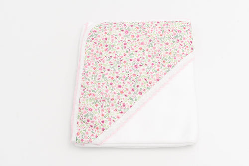Manta para bebé rosa dobrada, com o capuz de flores cor-de-rosa e a renda cor-de-rosa.