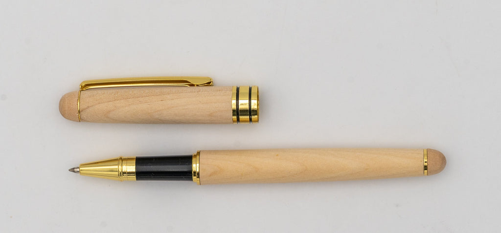 Caneta de madeira clara com tampa retirada, clipe dourado e zona de pega preta.