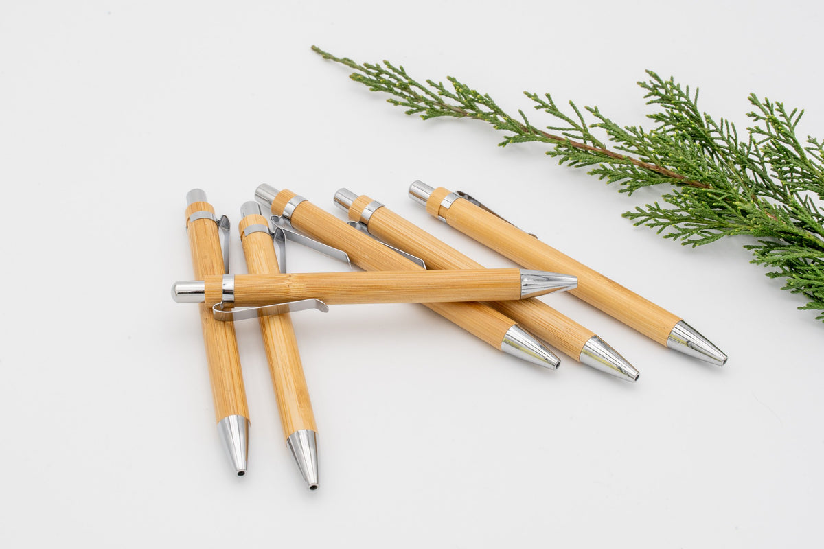 Grupo de canetas de bambu com anel e peças metálicas prateadas.