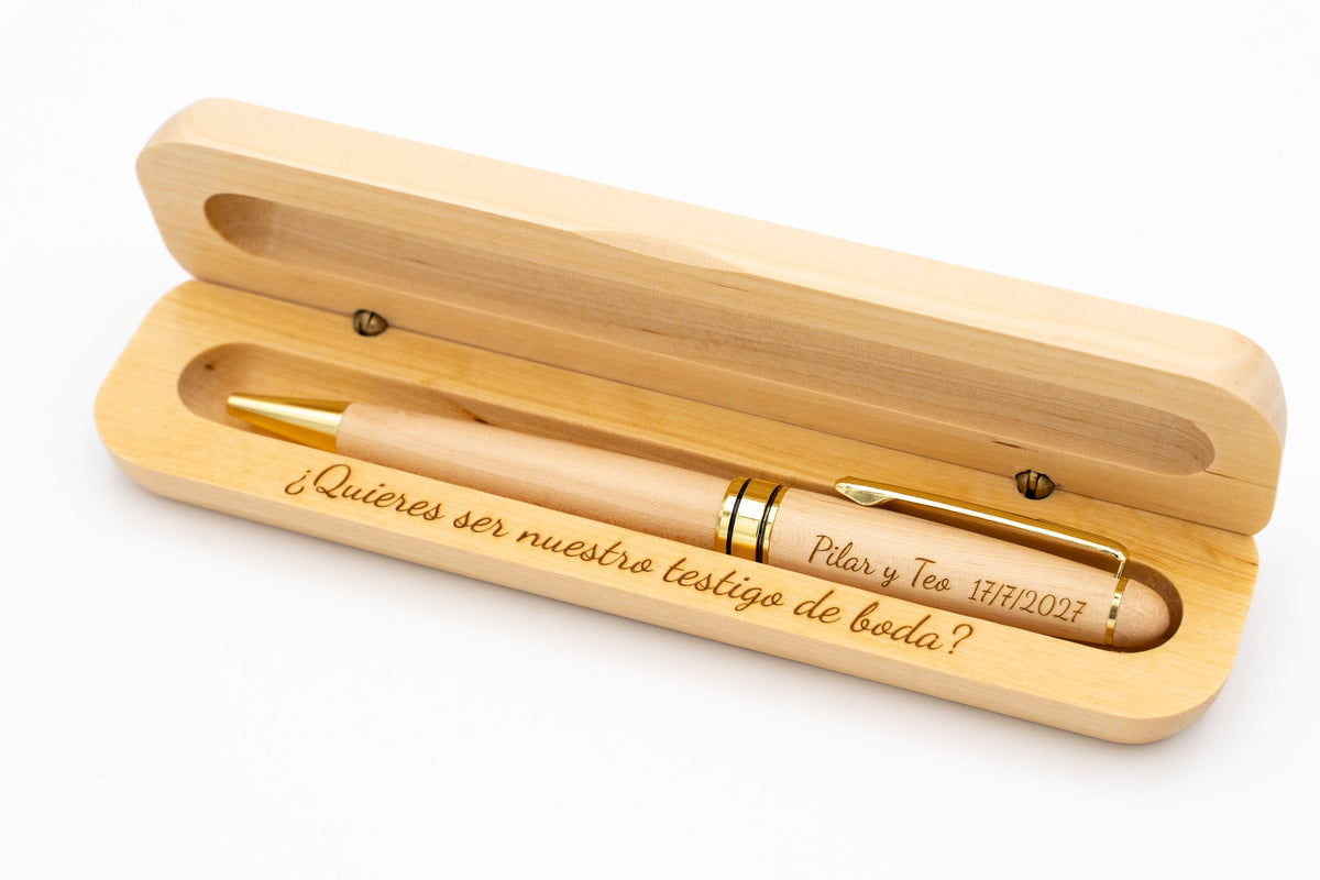 Exemplo de caneta de madeira clara com detalhes dourados num estojo aberto gravado para uma testemunha de casamento.