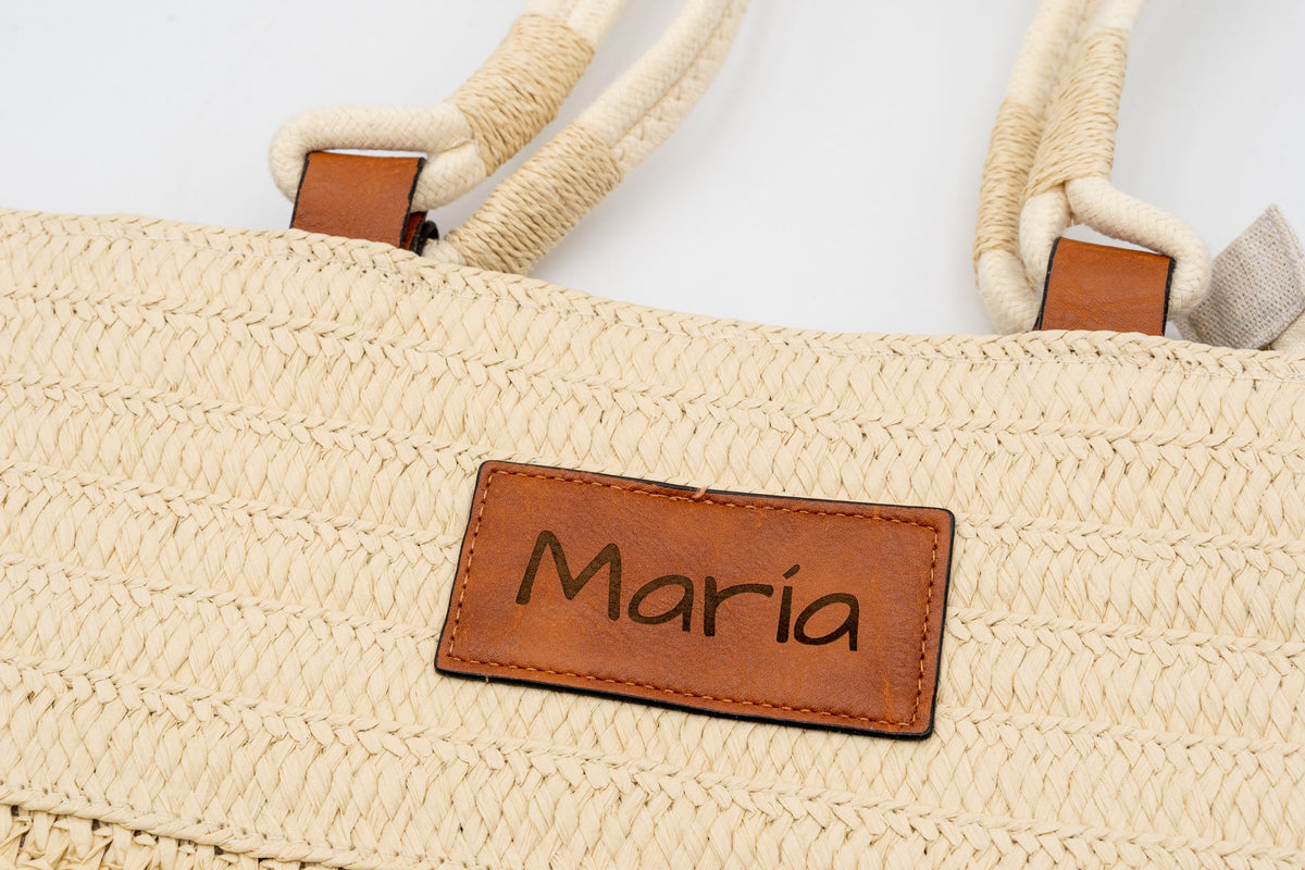 Etiqueta de uma mala de ráfia natural gravada com o nome María