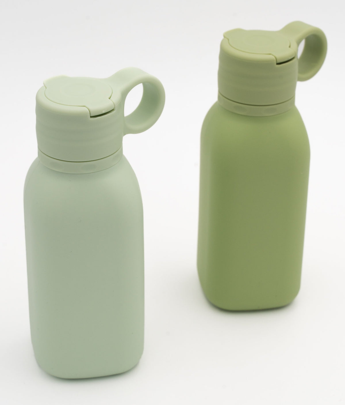 Duas garrafas verdes com tampas fechadas