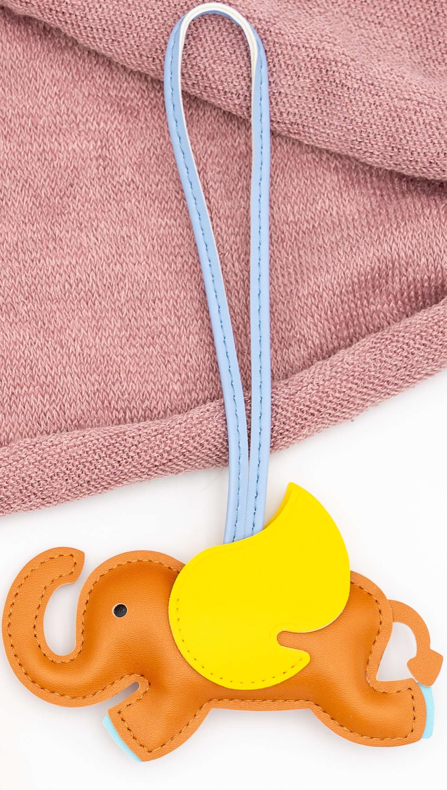 Elefante decorativo de polipiel naranja con ala amarilla y tira de sujeción azul.