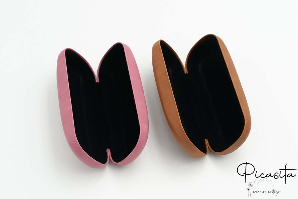 Vista superior de estuches rígidos abiertos con interiores en terciopelo negro y beige.