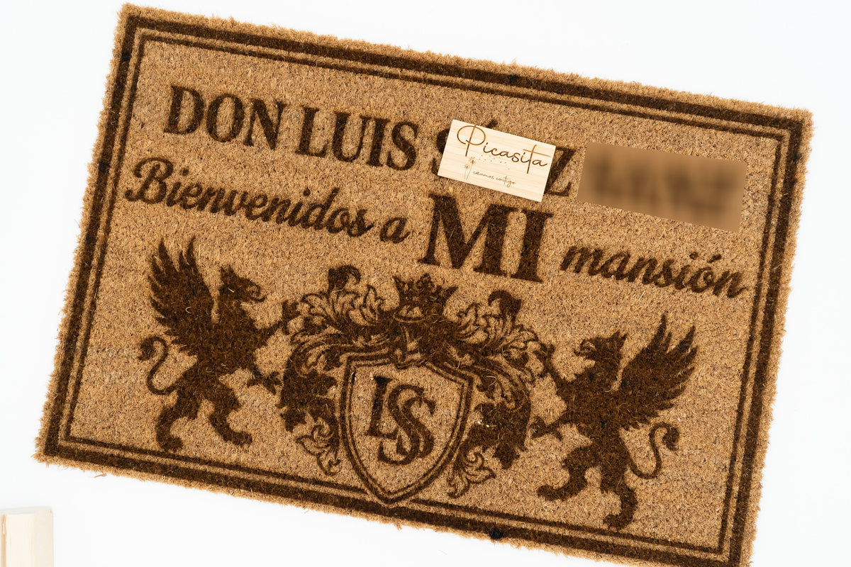 Felpudo con escudo heráldico y figuras de grifos grabado para entrada de mansión.