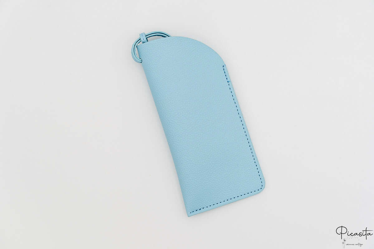 Protector de gafas en polipiel azul cielo con cordón de sujeción a juego.