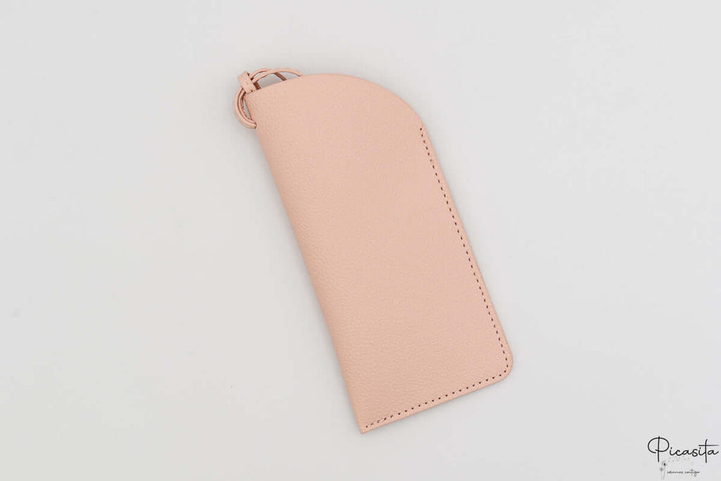 Detalle de funda de polipiel rosa para gafas con costuras reforzadas y tira.