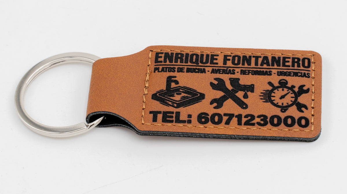 Porta-chaves retangular castanho com logótipo e texto de um serviço de canalização.