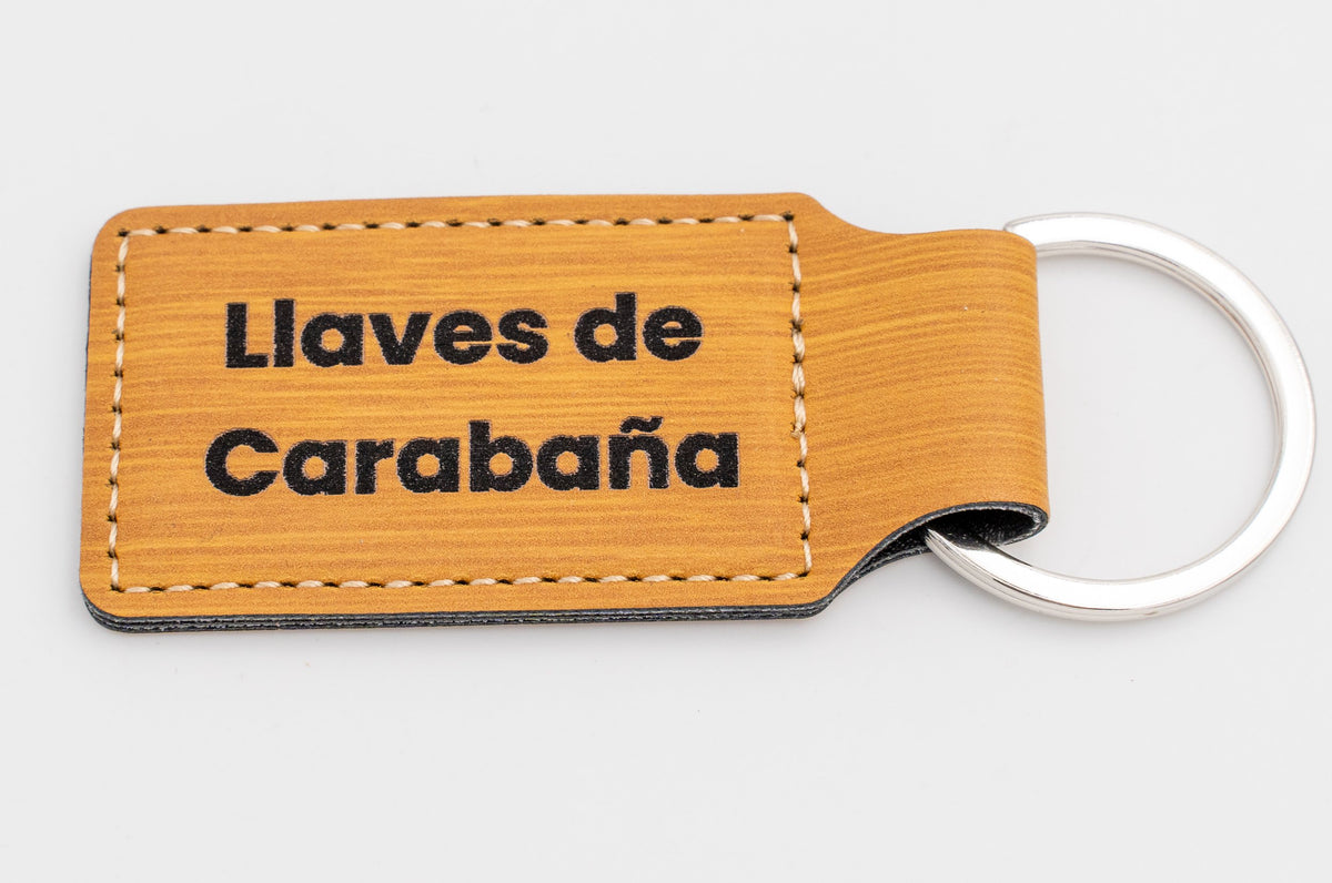 Porta-chaves retangular com acabamento madeira e texto escuro em duas linhas.