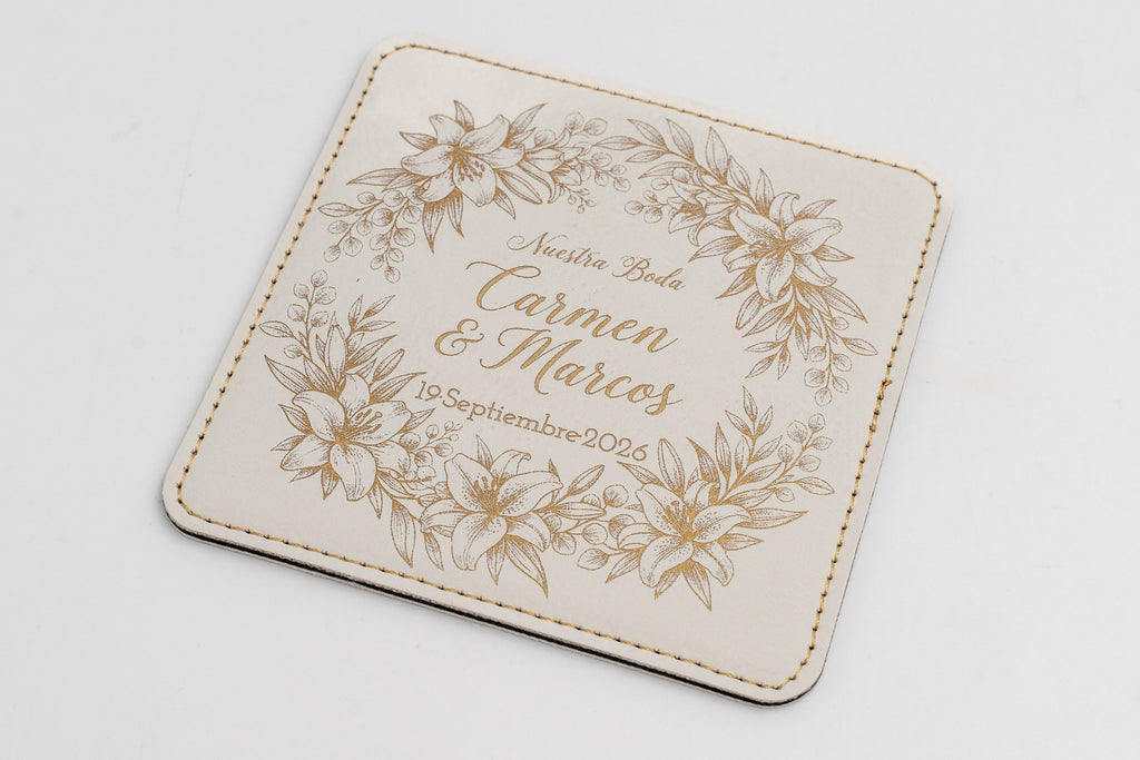 Base para copos quadrada branca com moldura floral e nomes em tom dourado.