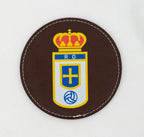 Base para copos redonda castanha com emblema de futebol a cores.
