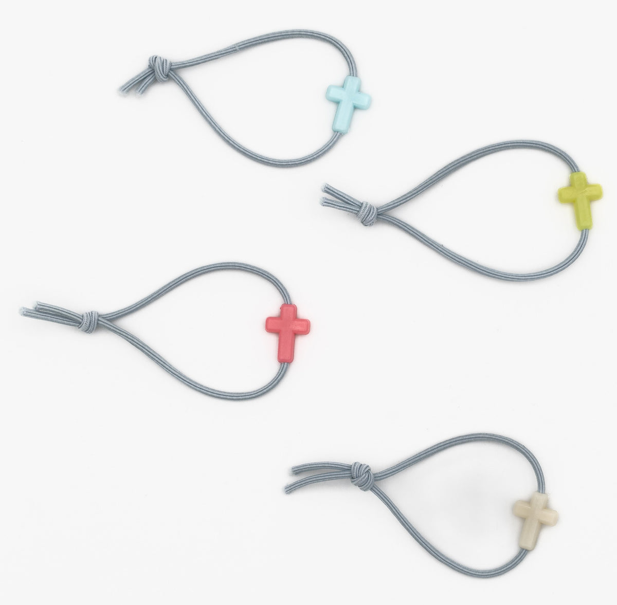 Quatro pulseiras infantis cinzentas com contas de silicone em forma de cruz de várias cores.