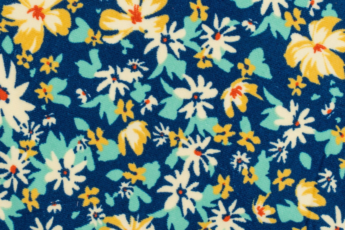 Grande plano de uma toalha azul-marinho com flores brancas e amarelas estampadas.