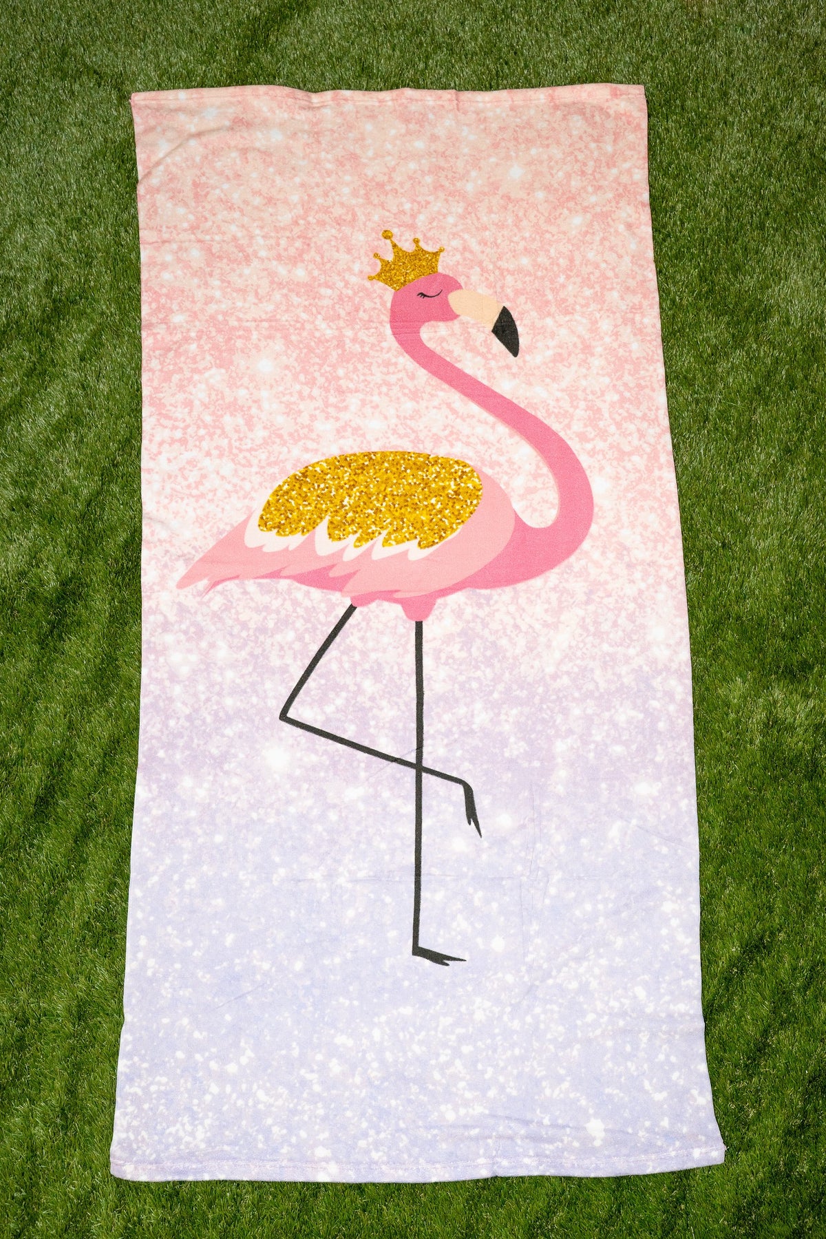 Toalha com degradê rosa e lilás e um desenho de um flamingo com coroa dourada.