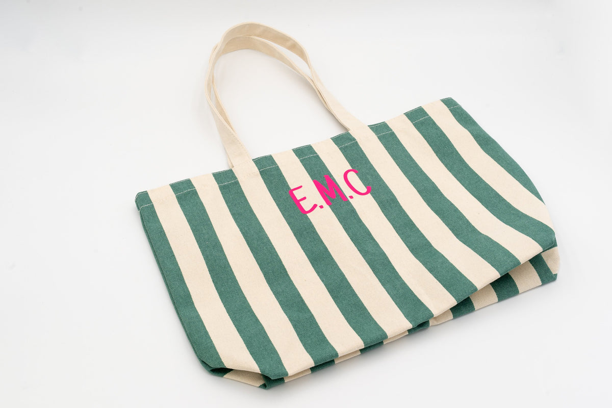 Tote bag de algodón con rayas verdes y blancas y personalización de iniciales en rosa.